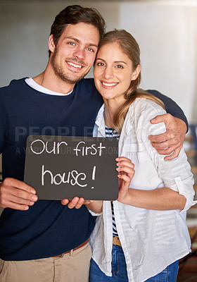 Buy stock photo Portrait of a happy couple holding a sign as they move into their new house
