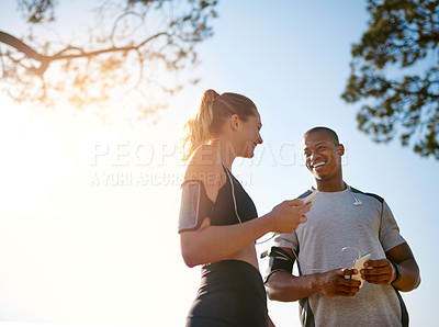 Buy stock photo Shot of a fit young couple working out together outdoors