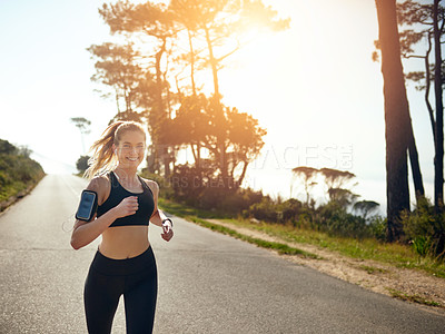 Buy stock photo Shot of a fit young woman going for a run outdoors