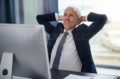 Buy stock photo Shot of a content mature businessman leaning back in his chair with his hands behind his head