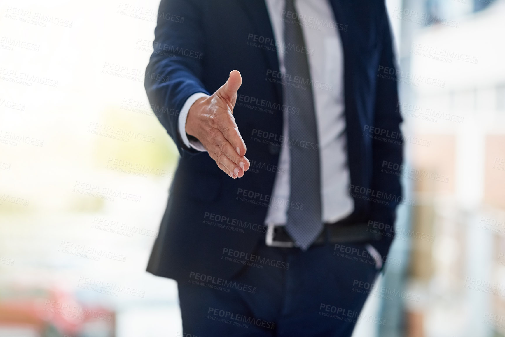 Buy stock photo Cropped shot of a businessman extending a handshake while standing in an office