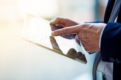 Buy stock photo Cloesup shot of a businessman using a digital tablet while standing in an office