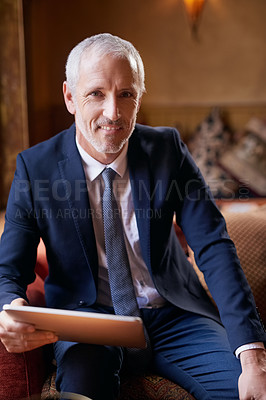 Buy stock photo Portrait of a well-dressed mature man using a digital tablet in a cafe after work
