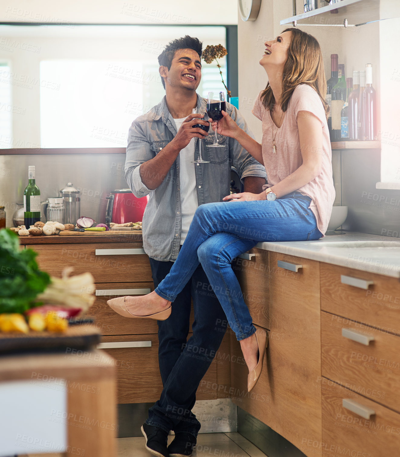 Buy stock photo Shot of an affectionate young couple drinking wine in the kitchen