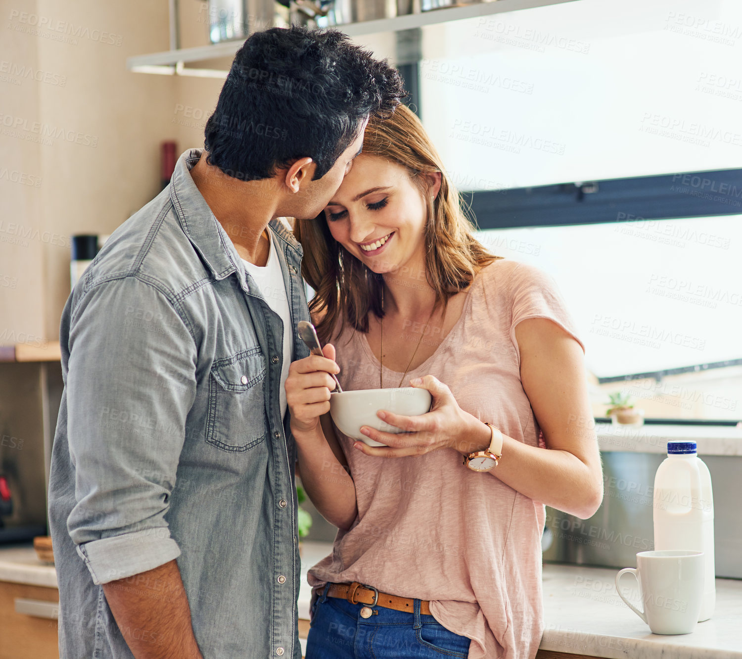 Buy stock photo Shot of an affectionate young couple standing in their kitchen