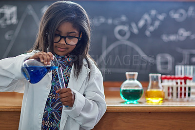 Buy stock photo Shot of a little girl in a lab coat doing a science experiment in a lab