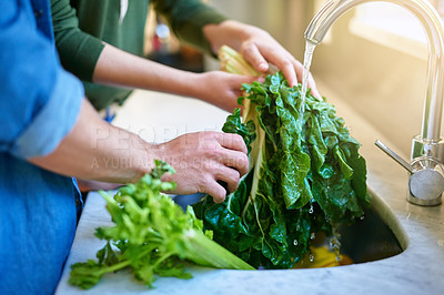 Buy stock photo Closeup shot of a couple washing spinach in their kitchen sink
