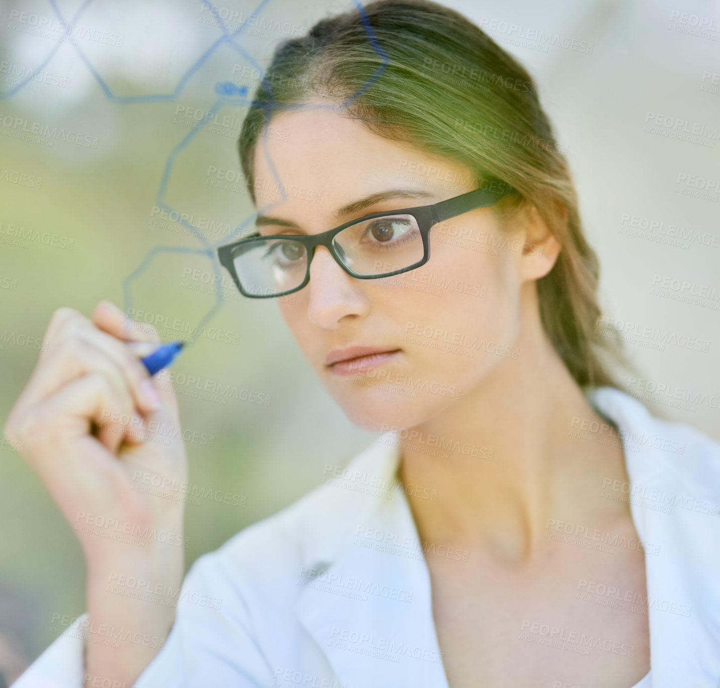 Buy stock photo Shot of a scientist writing formulas on a glass wall