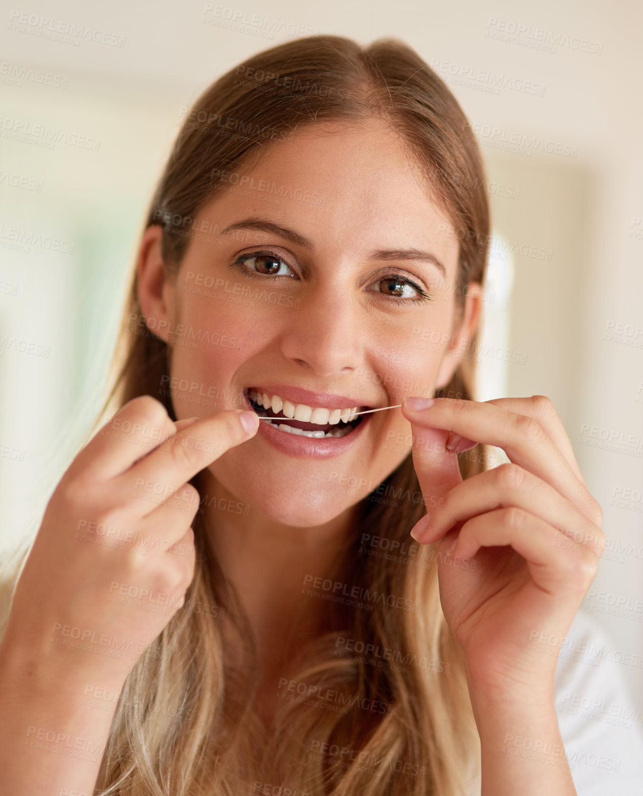 Buy stock photo Portrait of a young woman flossing her teeth at home