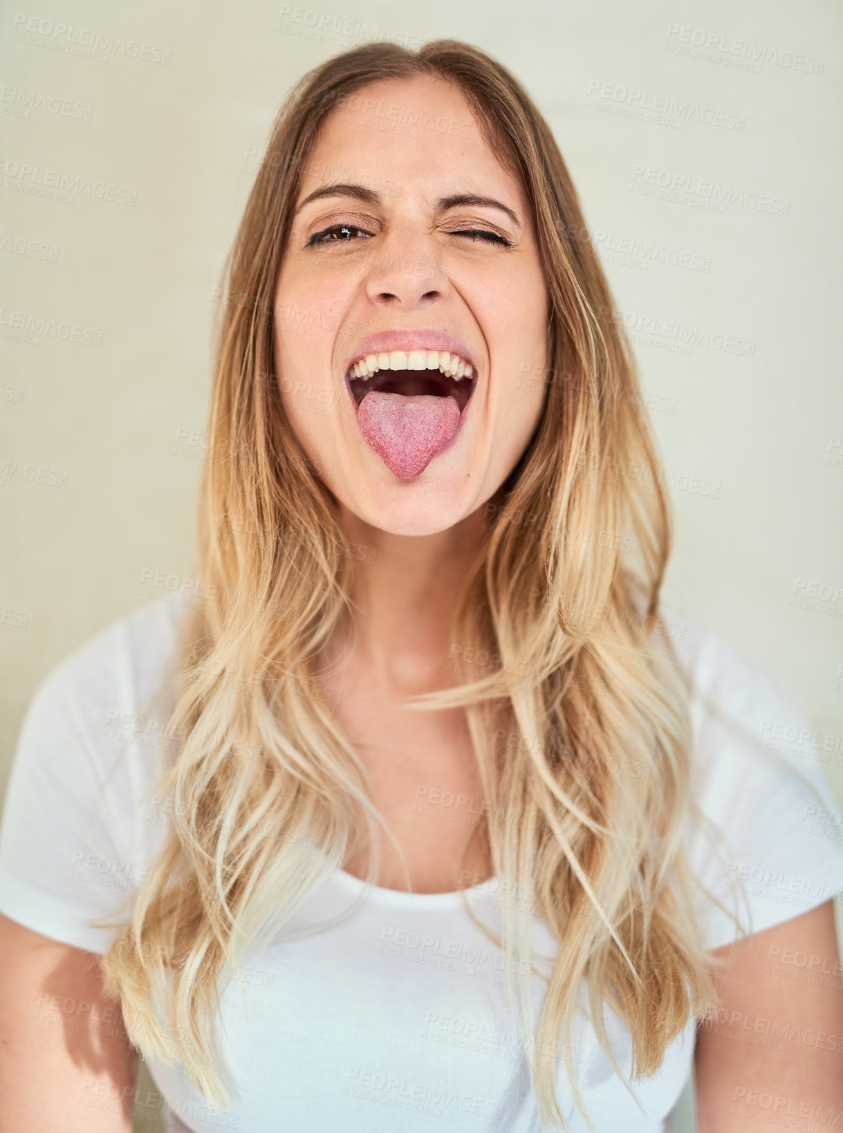 Buy stock photo Portrait of an attractive young woman sticking out her tongue