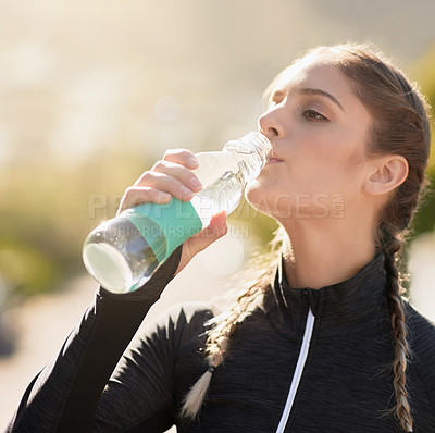 Buy stock photo Shot of an attractive young woman drinking water during her workout