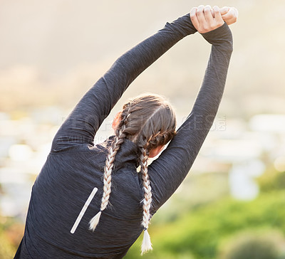 Buy stock photo Rearview shot of an unrecognizable young woman stretching before a workout