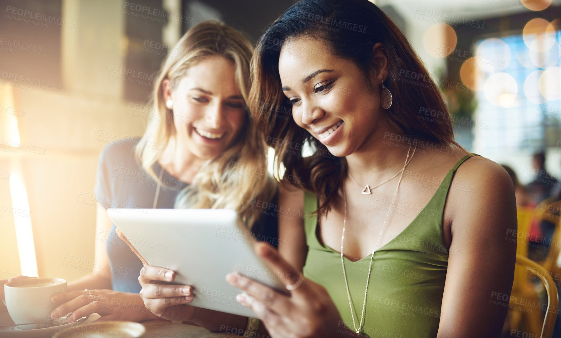 Buy stock photo Cropped shot of girlfriends sharing something on a digital tablet while sitting in a cafe