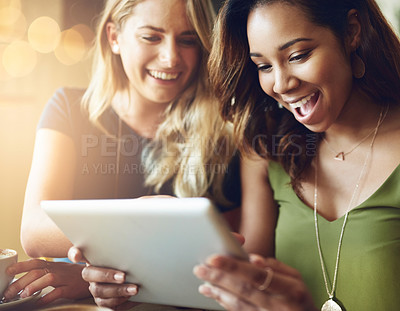 Buy stock photo Cropped shot of girlfriends sharing something on a digital tablet while sitting in a cafe
