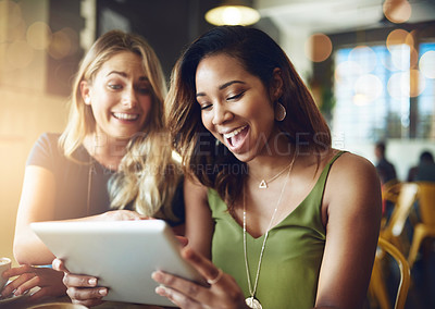 Buy stock photo Cropped shot of girlfriends sharing something on a digital tablet while sitting in a cafe