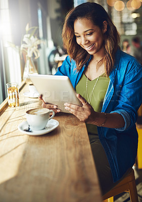 Buy stock photo Cropped shot of an attractive young woman using a digital tablet in a cafe