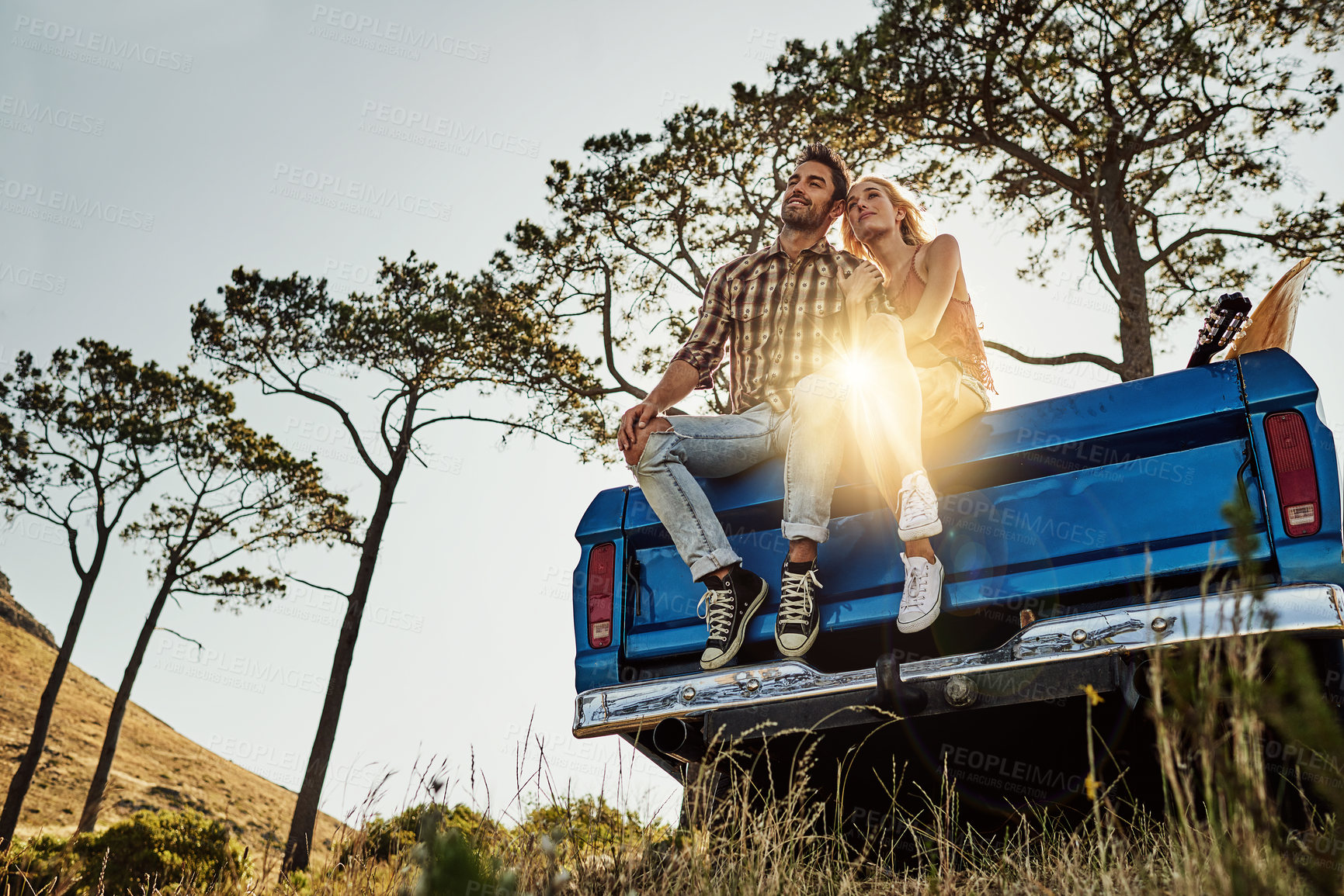 Buy stock photo Shot of an affectionate couple pulling over to admire the scenery while on a road trip