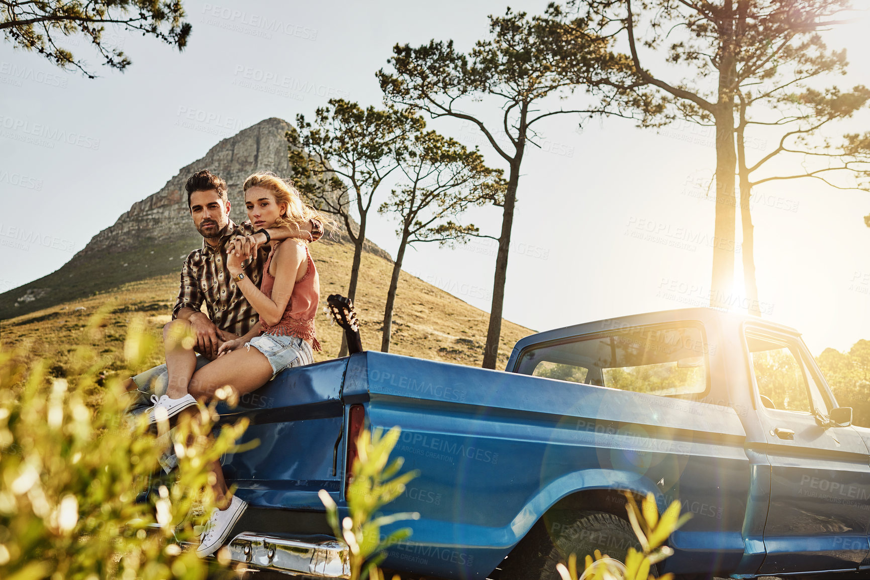 Buy stock photo Shot of an affectionate couple pulling over to admire the scenery while on a road trip