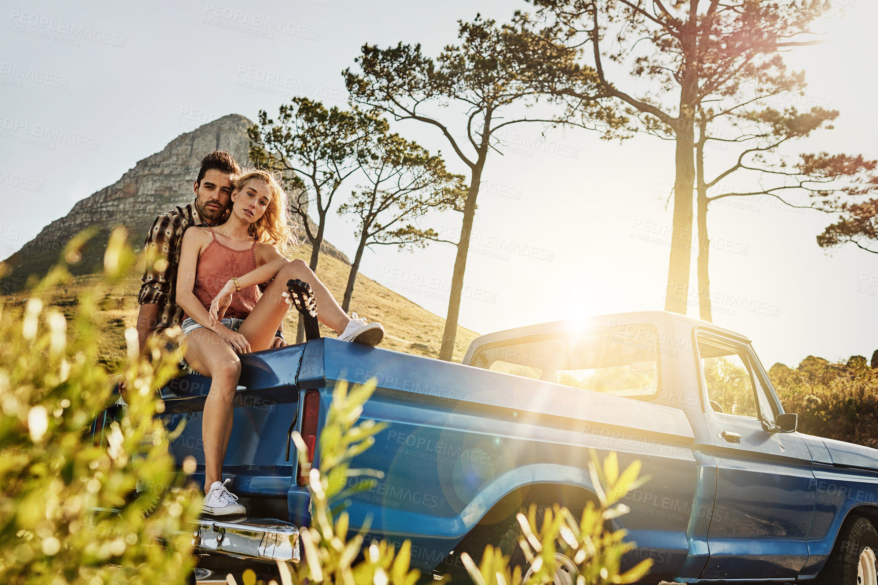 Buy stock photo Shot of an affectionate couple pulling over to admire the scenery while on a road trip