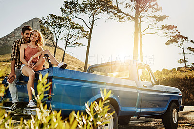 Buy stock photo Shot of an affectionate couple pulling over to admire the scenery while on a road trip