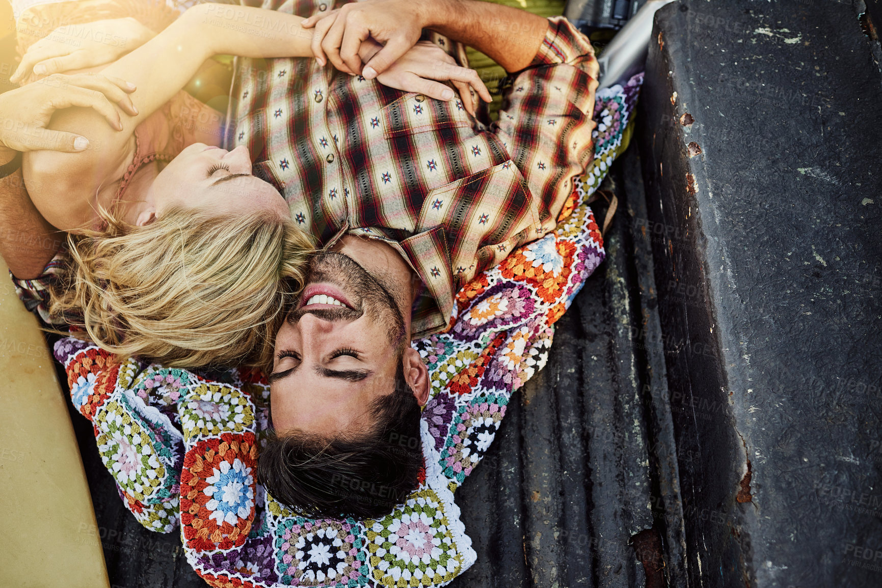 Buy stock photo Shot of a young couple lying at the back of a pickup truck to relax after a long drive