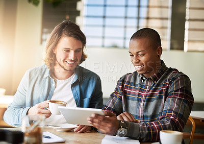 Buy stock photo Shot of  two friends using a tablet while having coffee in a coffee shop
