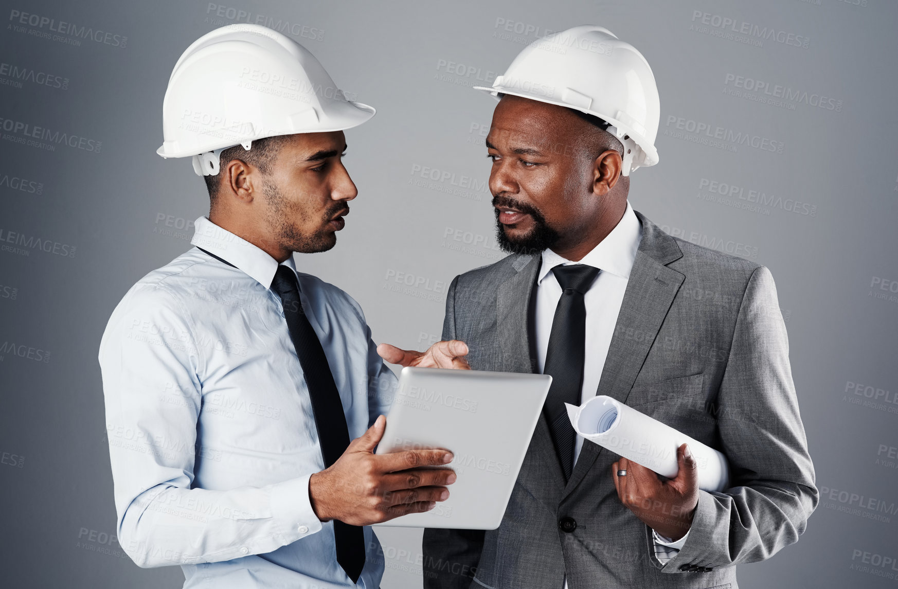 Buy stock photo Architect, men and discussion with tablet in studio for construction, research and renovation schedule. People, talking and online design, blueprint and floor plan for maintenance on gray background