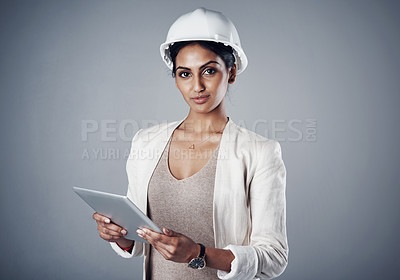 Buy stock photo Portrait of a well-dressed civil engineer using her tablet while standing in the studio