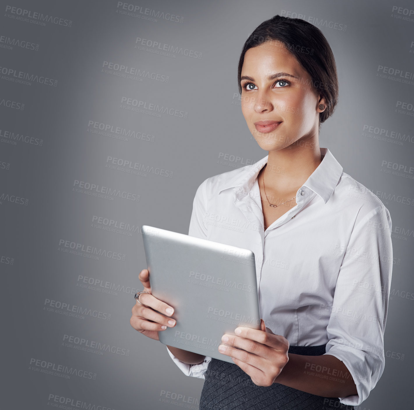 Buy stock photo Studio shot of a young businesswoman using a digital tablet against a gray background