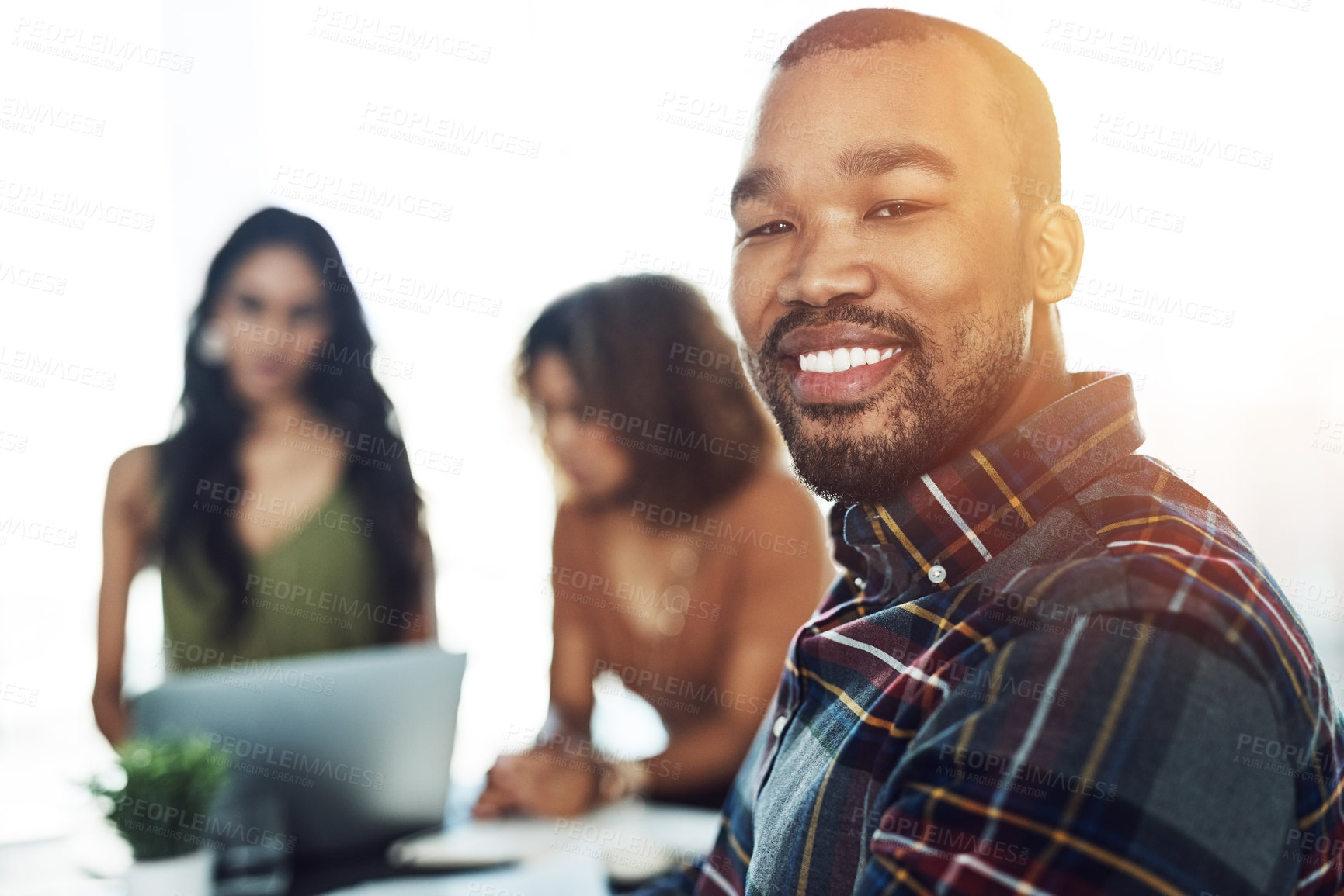 Buy stock photo Portrait of a confident young man having a meeting with his colleagues in the background