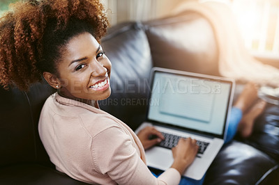 Buy stock photo High angle portrait of an attractive young woman using laptop while chilling at home on the sofa