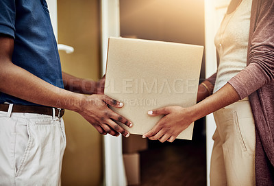 Buy stock photo Shot of a postal worker delivering a package to an unrecognizable female customer