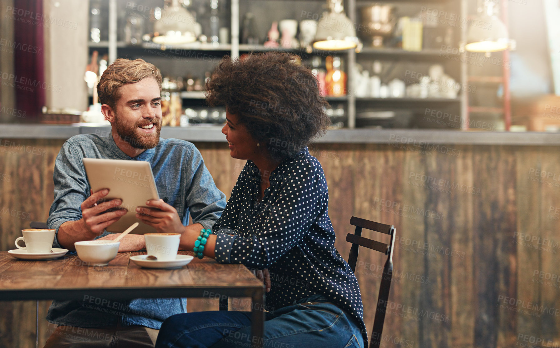 Buy stock photo Couple, tablet and laughing or talking in coffee shop with social media meme, bonding or funny online information. Interracial, people or happy in cafe with tech for comic post update or mockup space