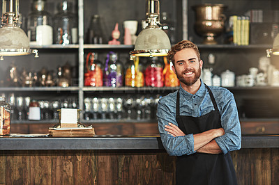 Buy stock photo Happy, crossed arms and portrait of male barista standing by the counter in his startup cafeteria. Smile, success and young man small business owner with confidence in coffee shop or restaurant.