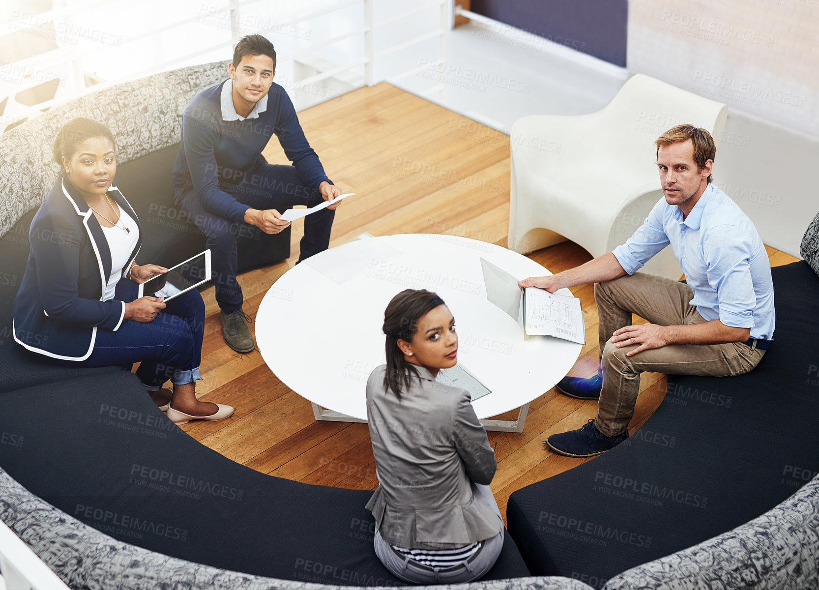 Buy stock photo High angle portrait of a group of colleagues having a meeting around a table in a modern office