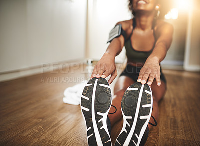 Buy stock photo Shot of a young woman doing stretching exercises at home