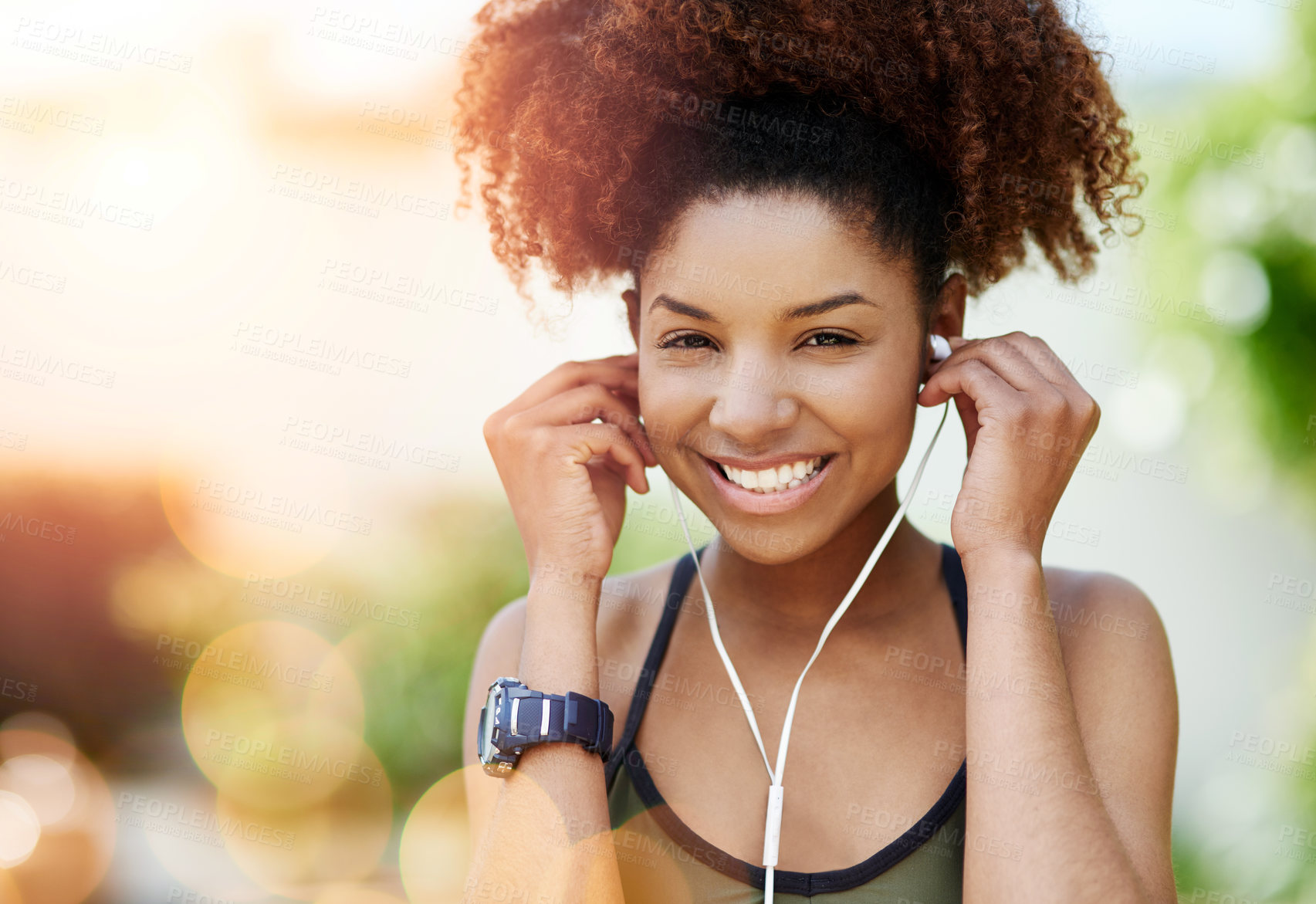 Buy stock photo Cropped shot of a young woman inserting her earphones before a run