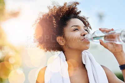 Buy stock photo Cropped shot of a young woman enjoying a bottle of water while out for a run