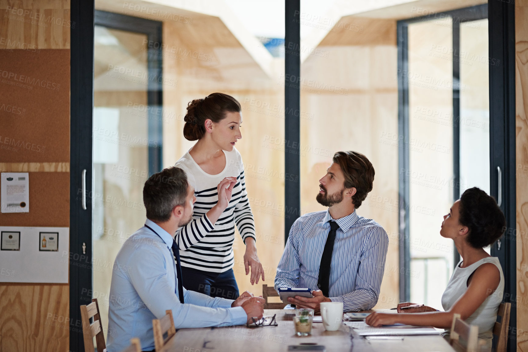 Buy stock photo Portrait of a group of colleagues talking together around a table in an office