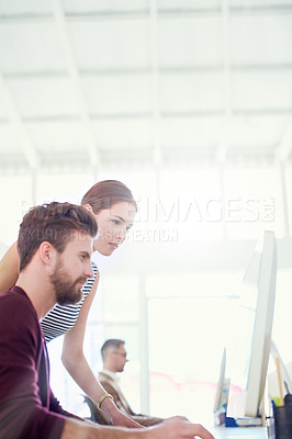 Buy stock photo Shot of two colleagues working together on a computer in an office