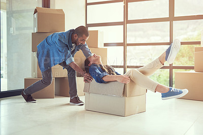 Buy stock photo Shot of a happy young couple having fun while moving into their new home