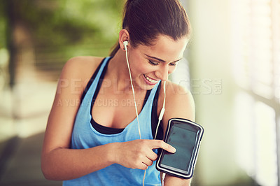 Buy stock photo Shot of a young woman starting her playlist before working out