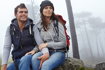 Buy stock photo Shot of a young couple taking a break while out hiking