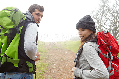 Buy stock photo Rearview shot of a young couple hiking along a nature trail