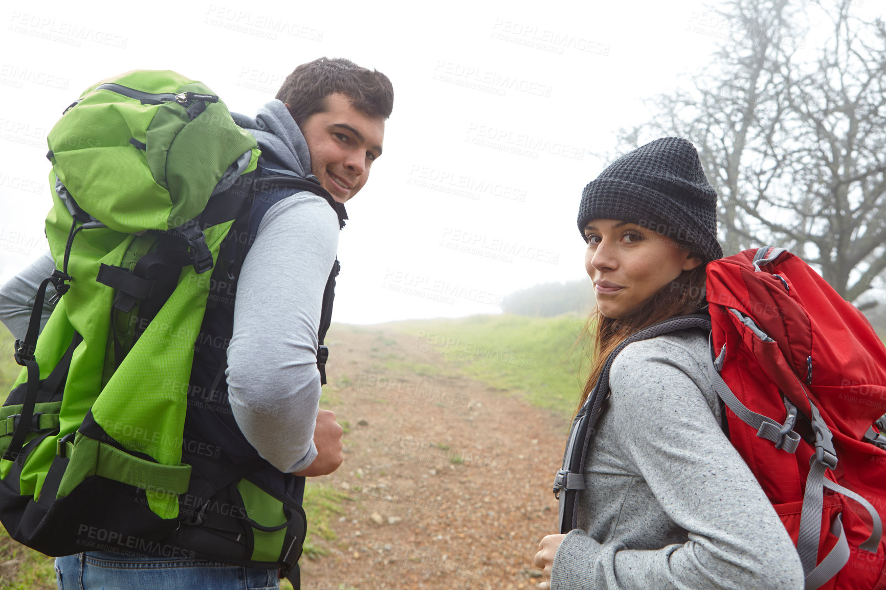 Buy stock photo Rearview shot of a young couple hiking along a nature trail