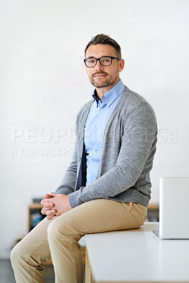 Buy stock photo Cropped portrait of a businessman sitting a desk in his office