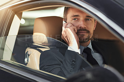 Buy stock photo Shot of a businessman using his phone while driving a car