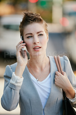 Buy stock photo Cropped shot of a young businesswoman talking on her cellphone while out in the city