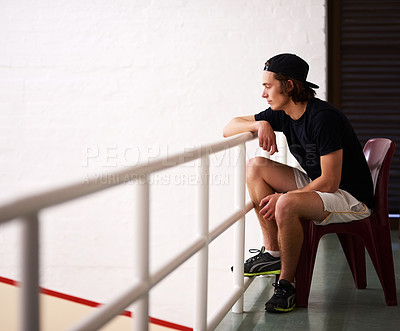 Buy stock photo Shot of a handsome young man watching a game of squash