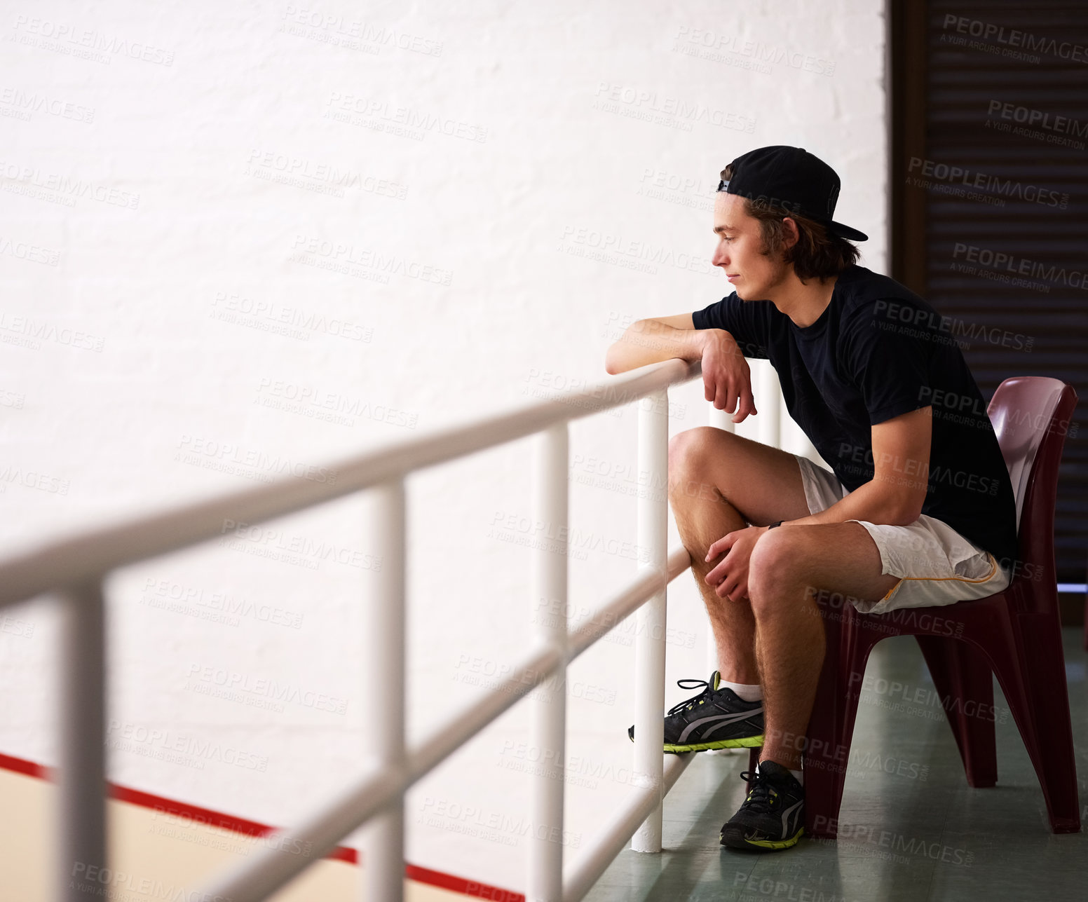 Buy stock photo Shot of a handsome young man watching a game of squash